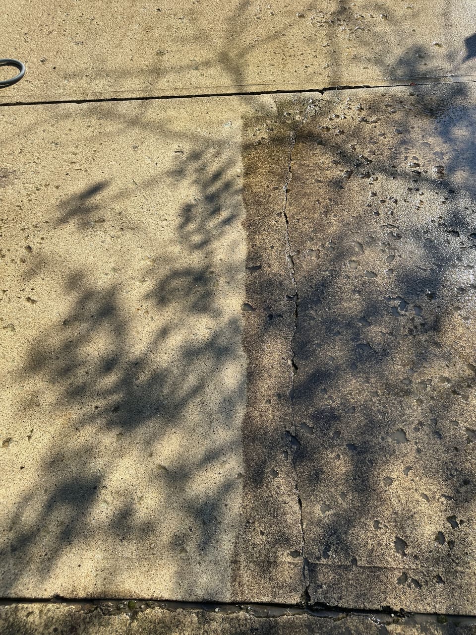 Concrete slab mid wash with a sharp line between clean and dirty
