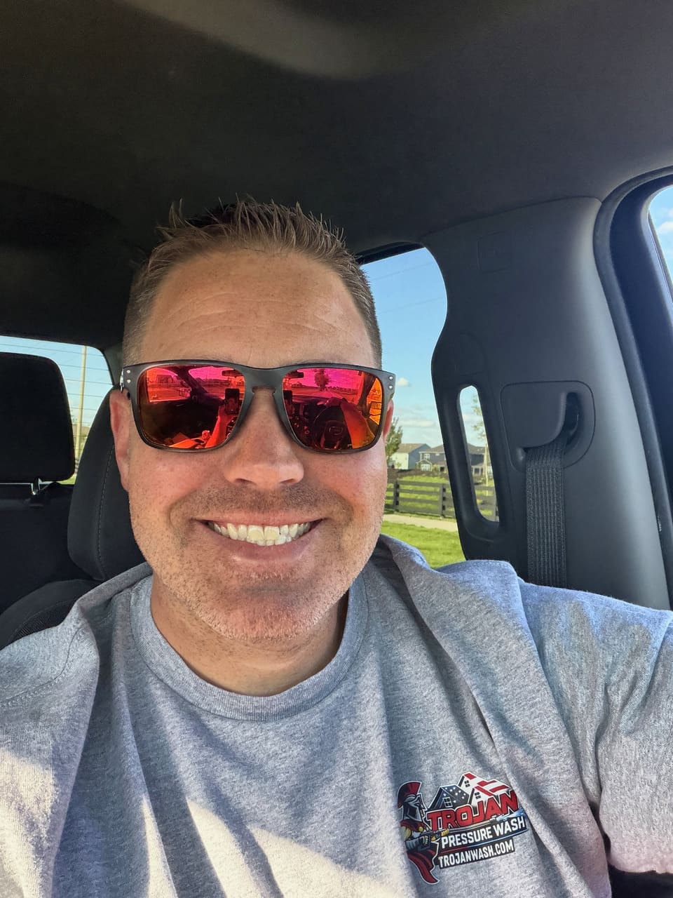The owner of Trojan Pressure Wash smiling in his truck