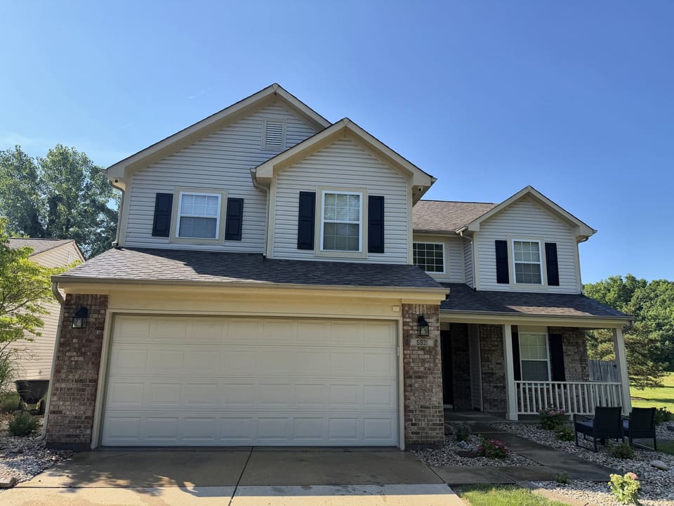 Front of a cream two story home with brick accents after a wash