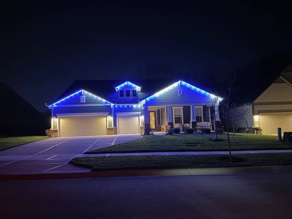 Ranch home with blue lights along the roofline and gables
