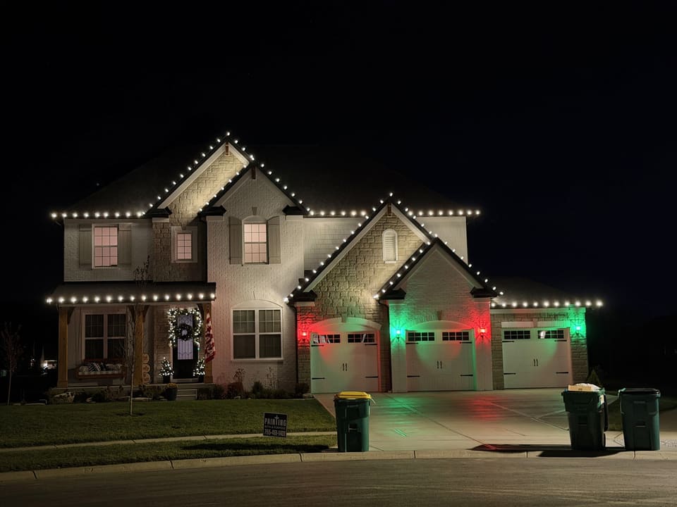 Home with white roofline lights and red and green garage lights