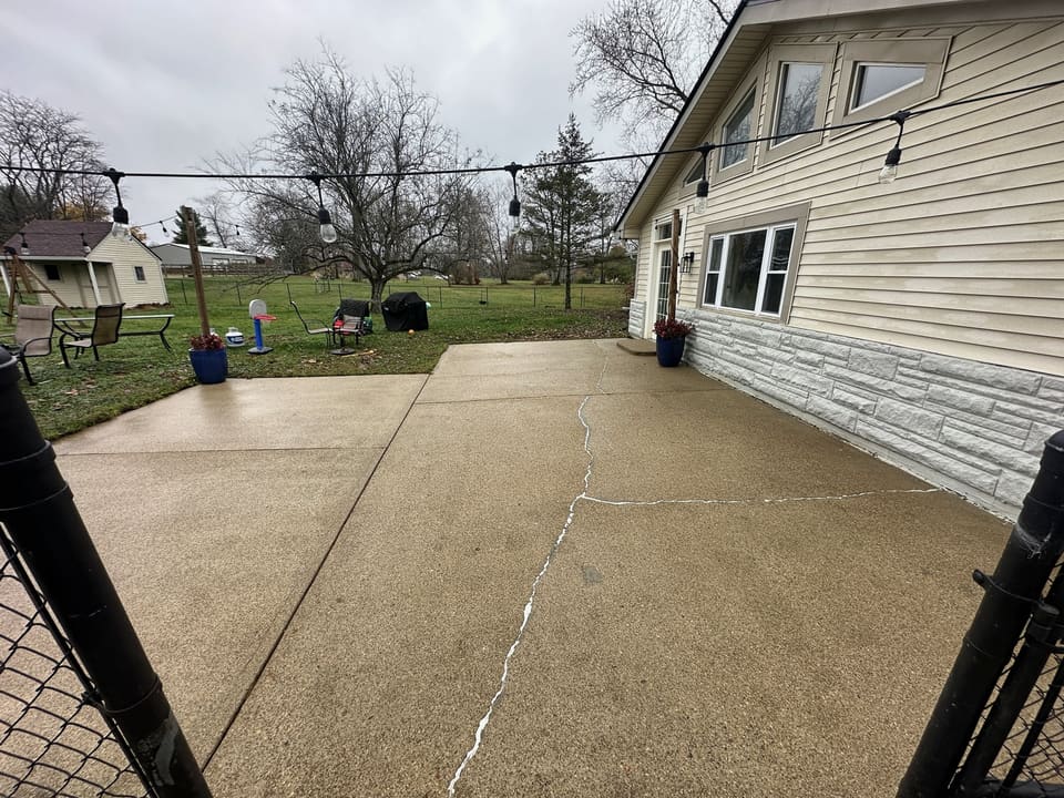 Large back patio washed clean behind a cream and stone home