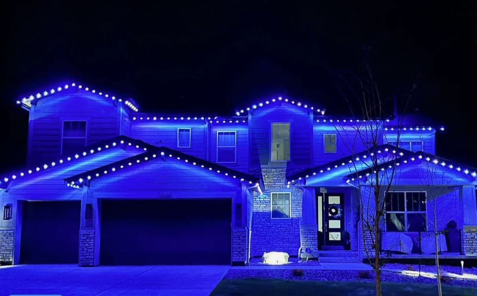 Large two story home with permanent lights set to bright blue