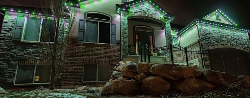 The same stone home with permanent lights set to green