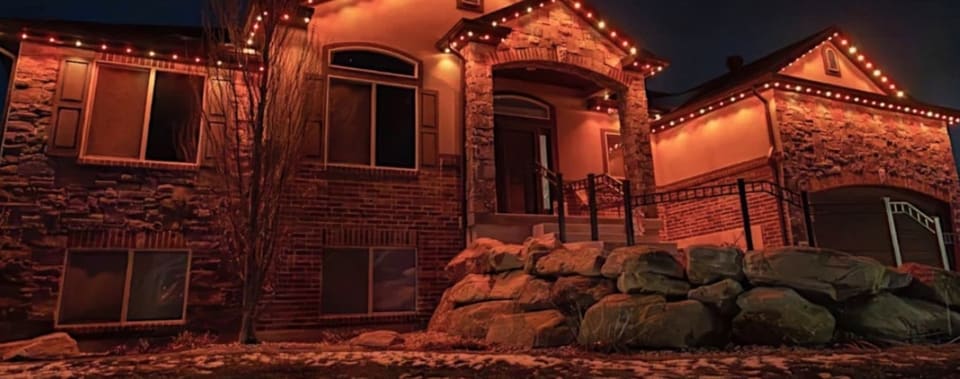 The same stone home with permanent lights set to orange