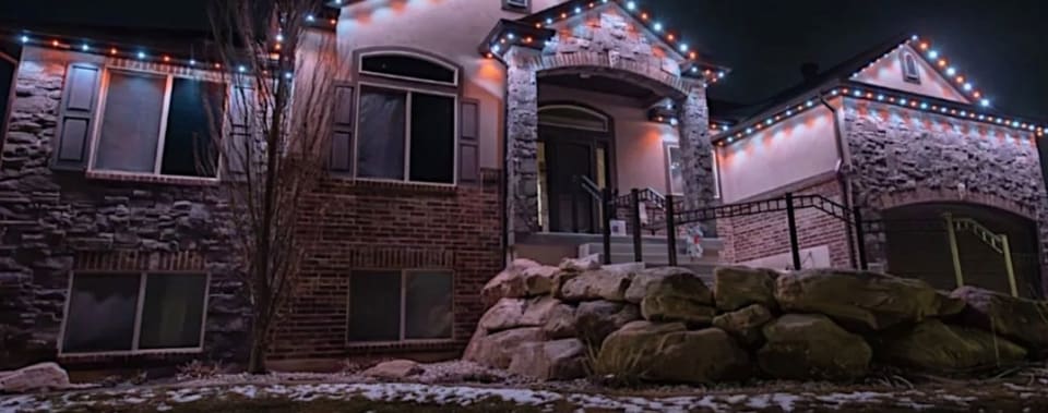 Stone home with permanent roofline lights set to white