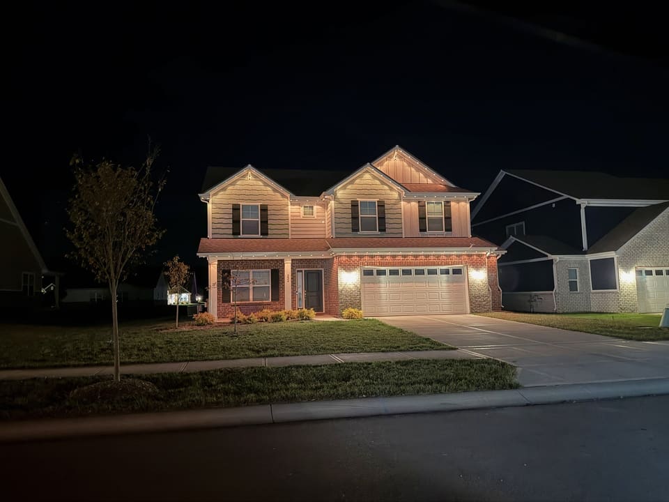The same two story home with permanent lights set to a warm white