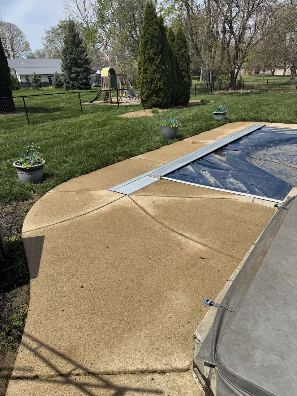 Pool deck coping halfway through a wash, clean concrete next to stained concrete