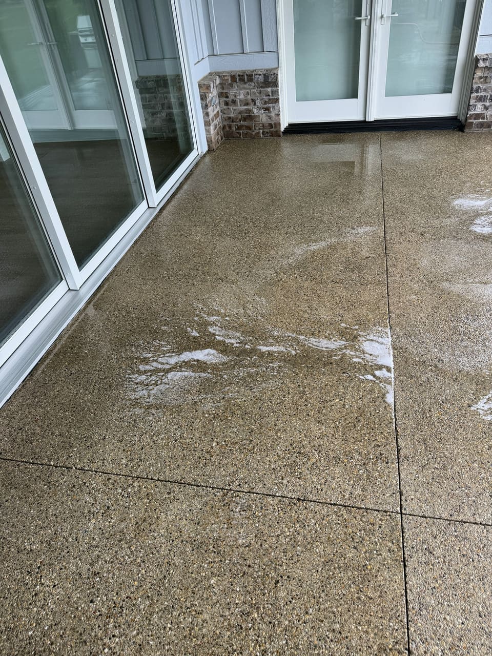 Covered porch with clean exposed aggregate concrete and sliding doors
