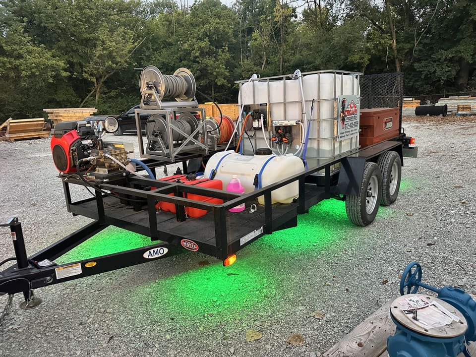 Trojan Pressure Wash equipment trailer with green underglow at night