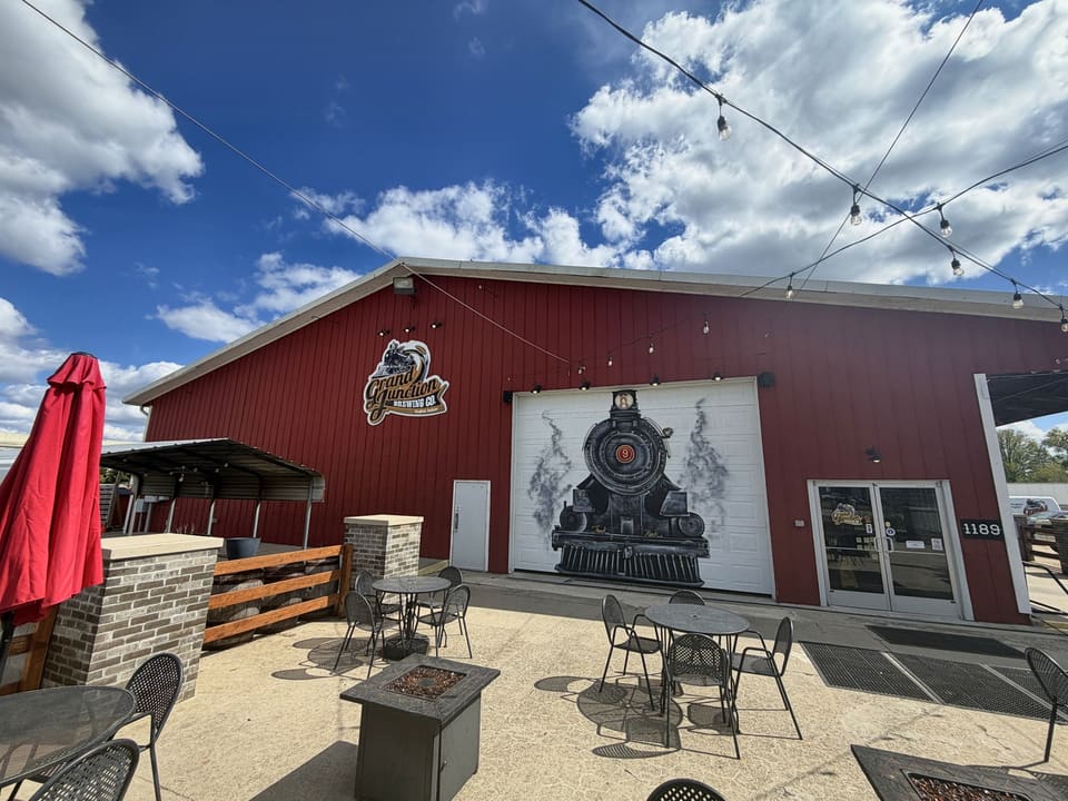 Red barn venue with a locomotive mural and clean patio seating