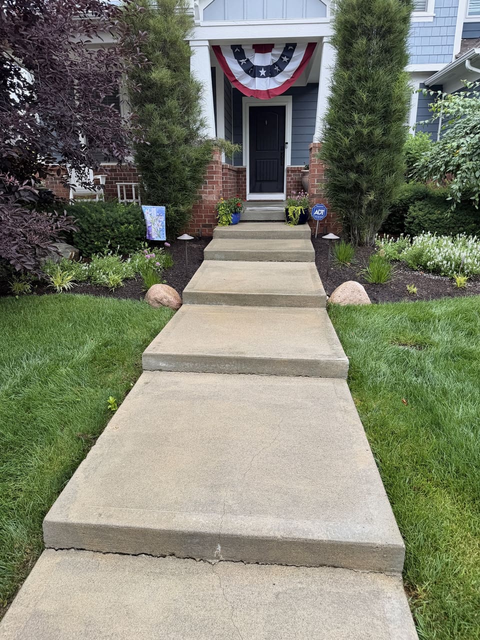 Front walk washed clean up to a porch with an American flag bunting