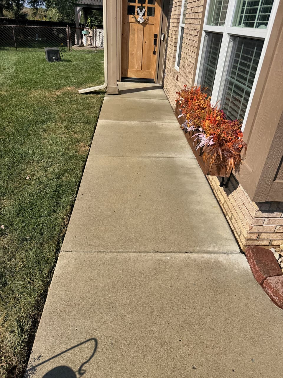 Clean front walk leading to a wooden front door
